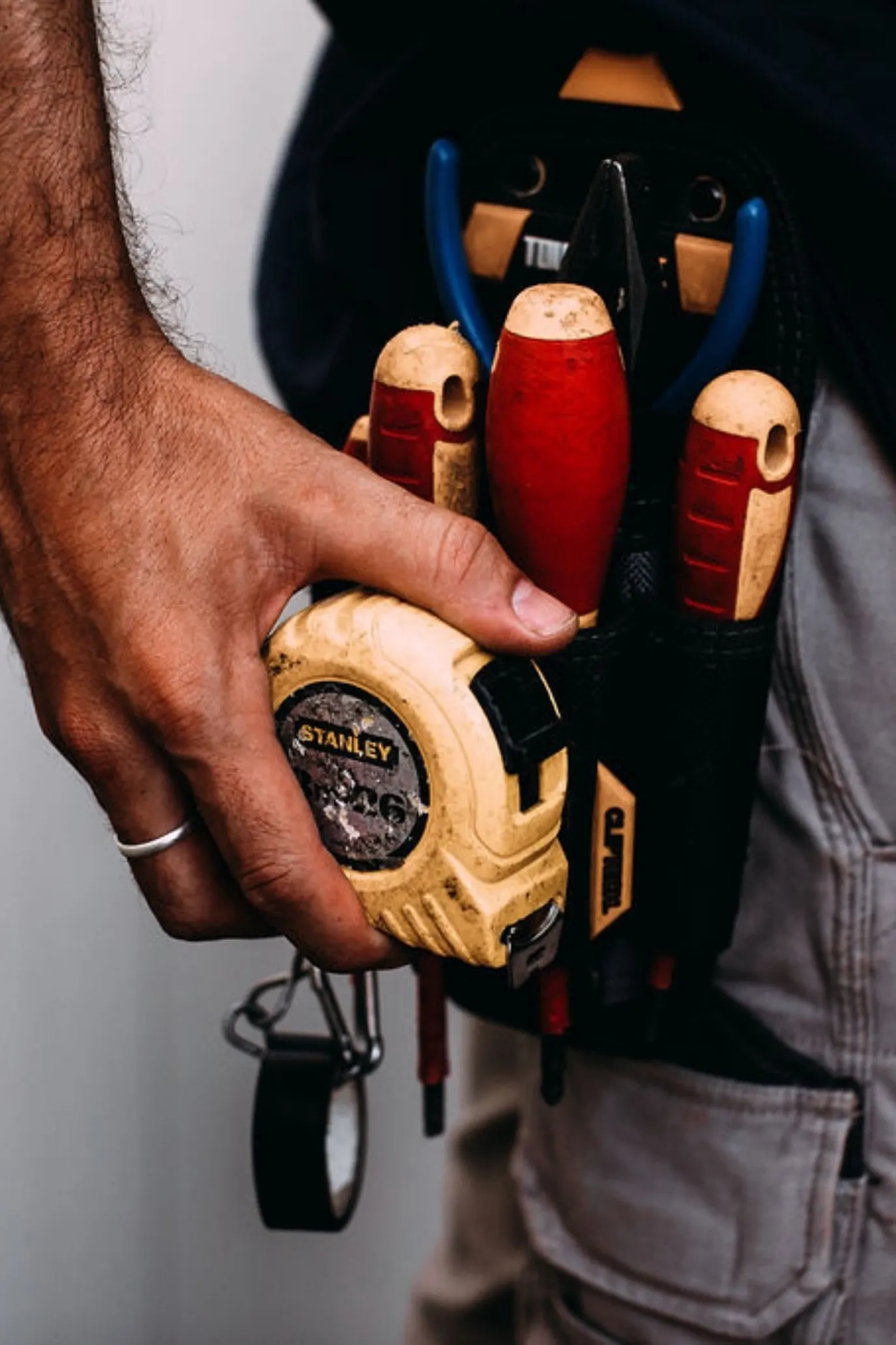 Ceinture d'outils d'un chauffagiste avec tournevis et mètre ruban