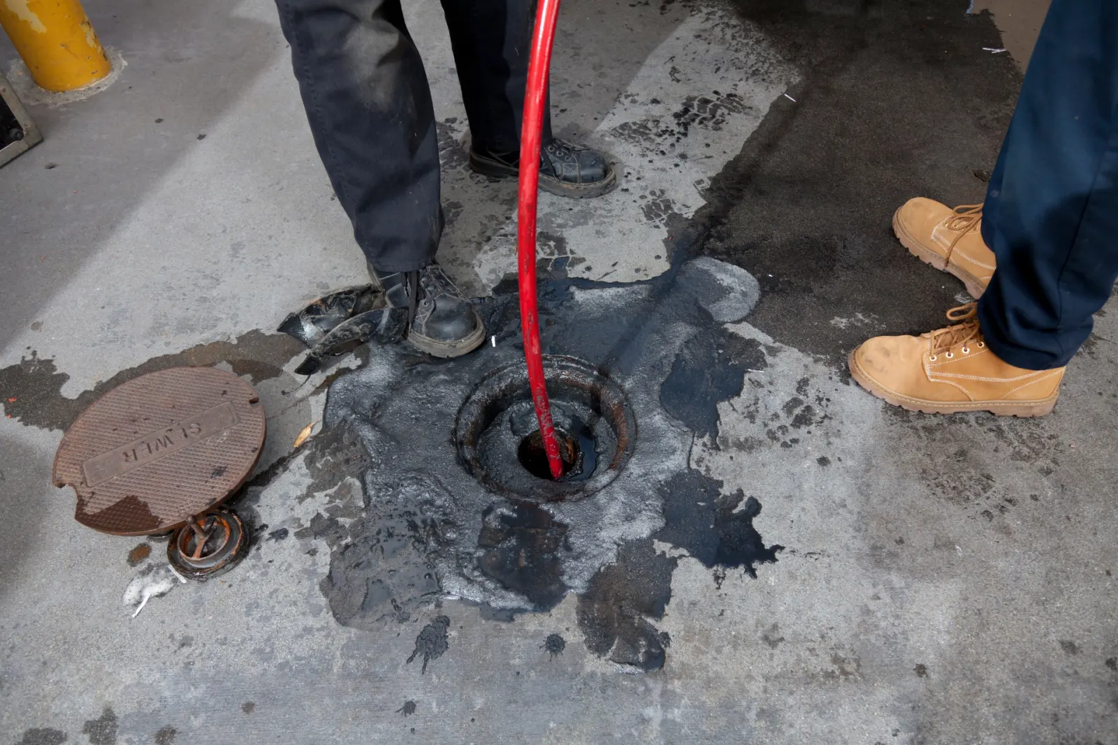 Tuyau d’hydrocurage introduit dans un regard d’égout