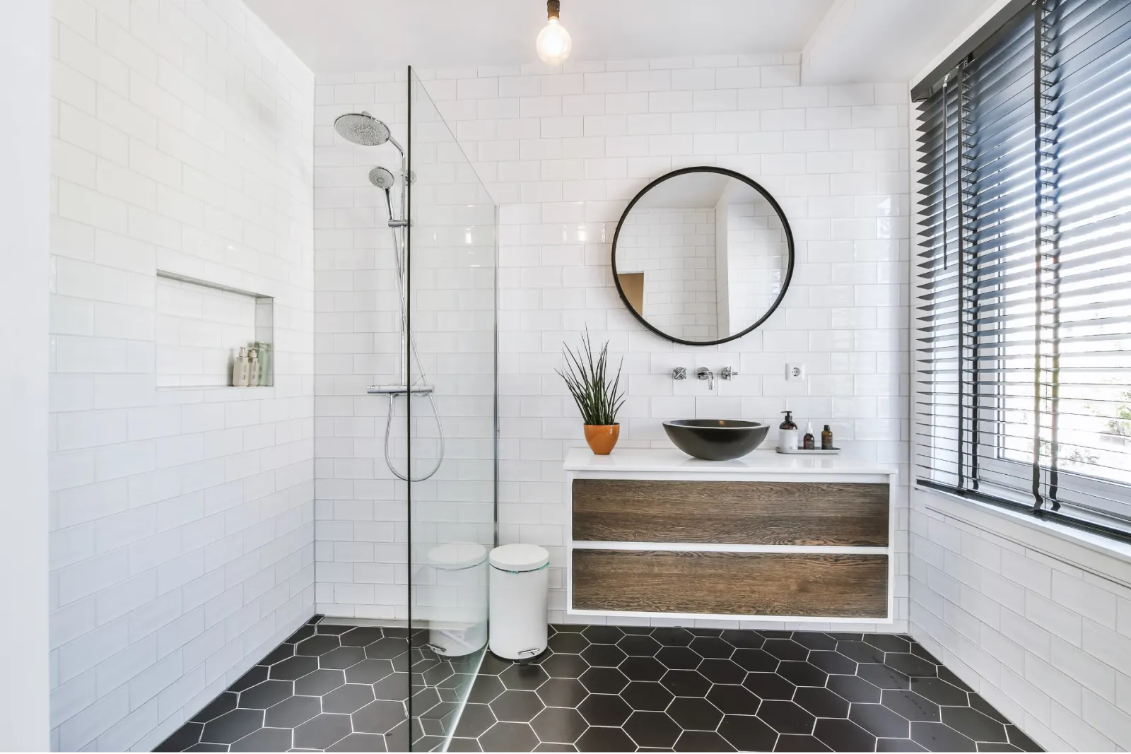 Salle de bains avec douche à l'italienne, vasque et miroir rond