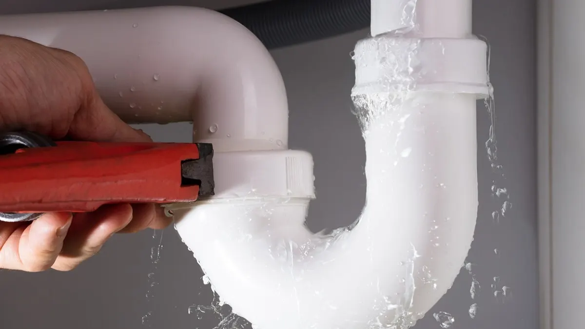 Siphon d'évier en PVC resserré avec une clé